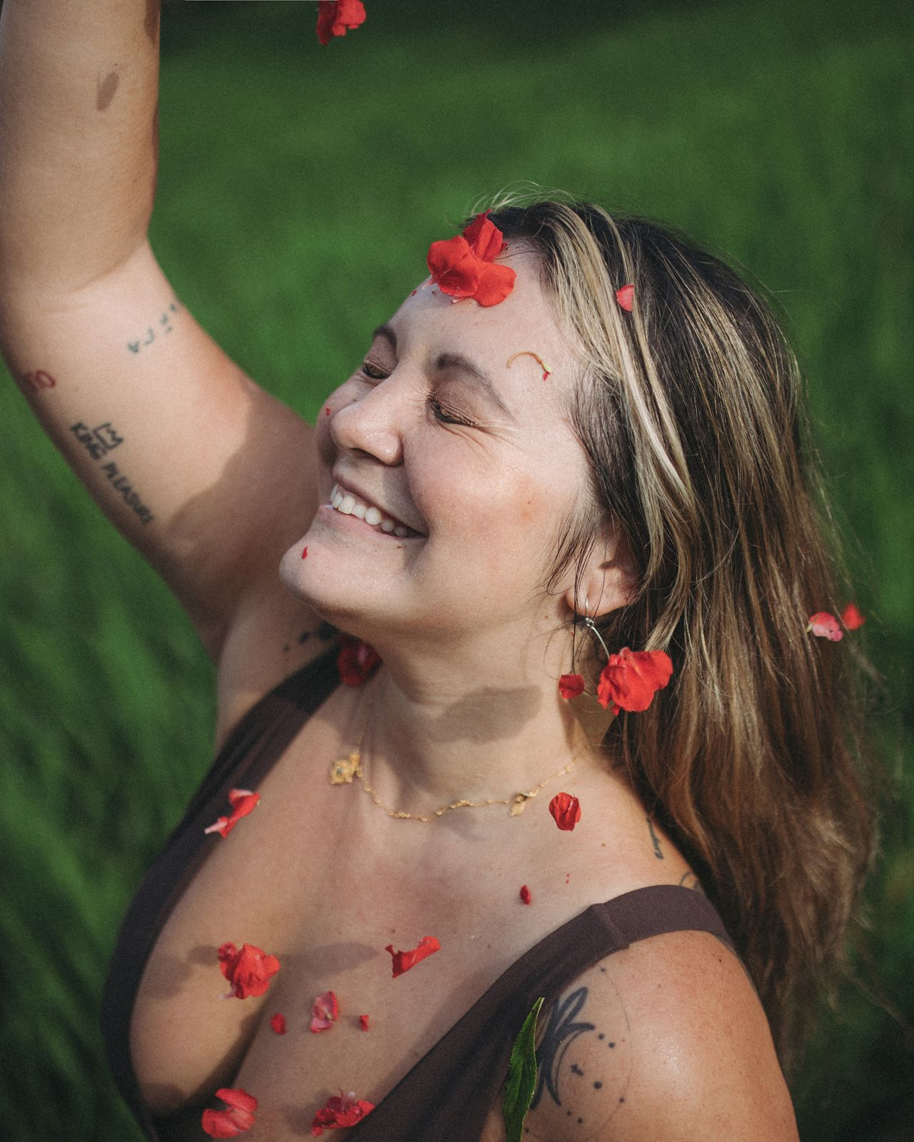 Diana Might smiling among red flowers